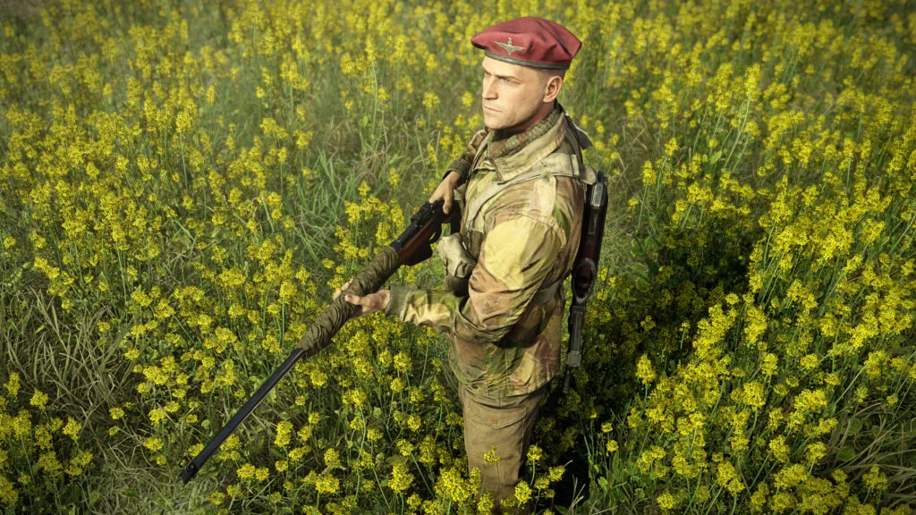 Karl Fairburne stands in a field of yellow flowers dressed in his Airborne Elite attire.